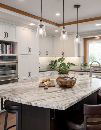 A kitchen with a marble island and stainless steel appliances.
