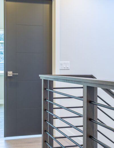 A gray door with a metal railing in a home.