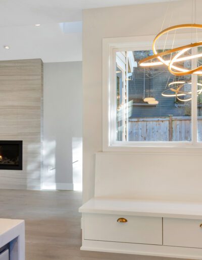 A white kitchen with a fireplace and a bench.