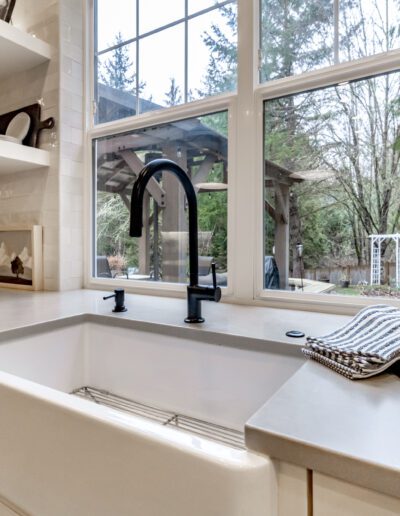 A white kitchen with a window and a sink.