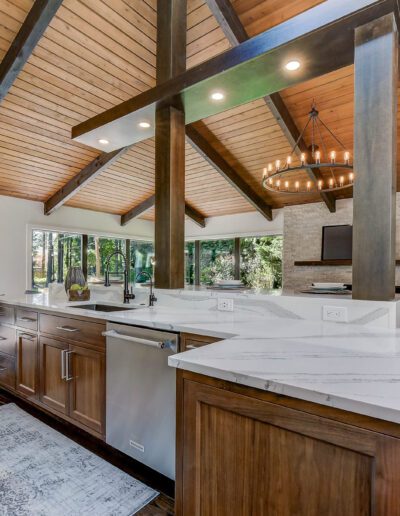 A modern kitchen with wood ceilings and a large island.
