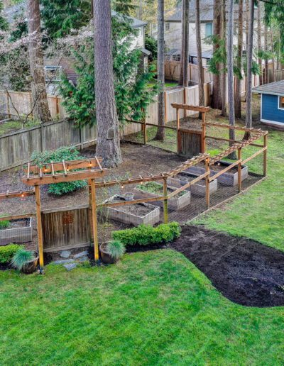 An aerial view of a backyard with trees and a garden.