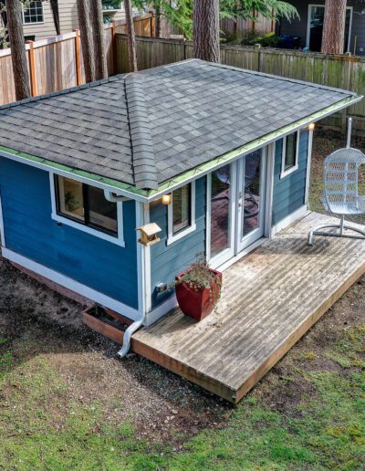 An aerial view of a blue shed in a backyard.