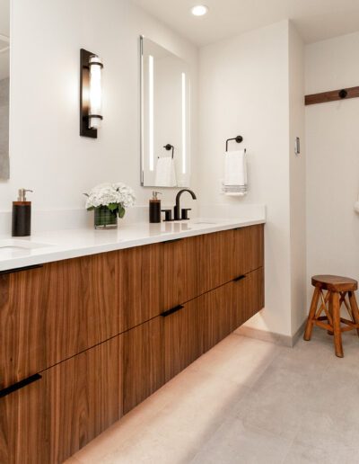 A modern bathroom with wooden cabinets and mirrors.